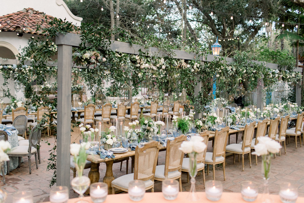 Long tables under the oaks at Rancho Las Lomas, greenery overhead