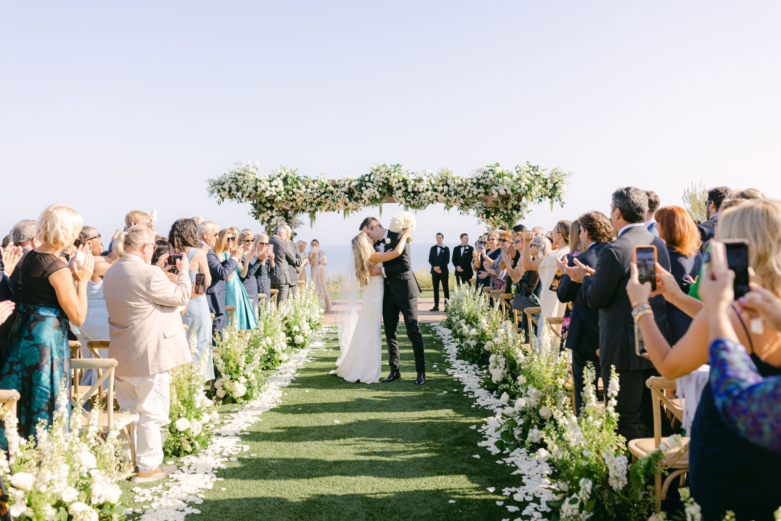 The recessional beneath a white floral arch above the Pacific at Terranea Resort