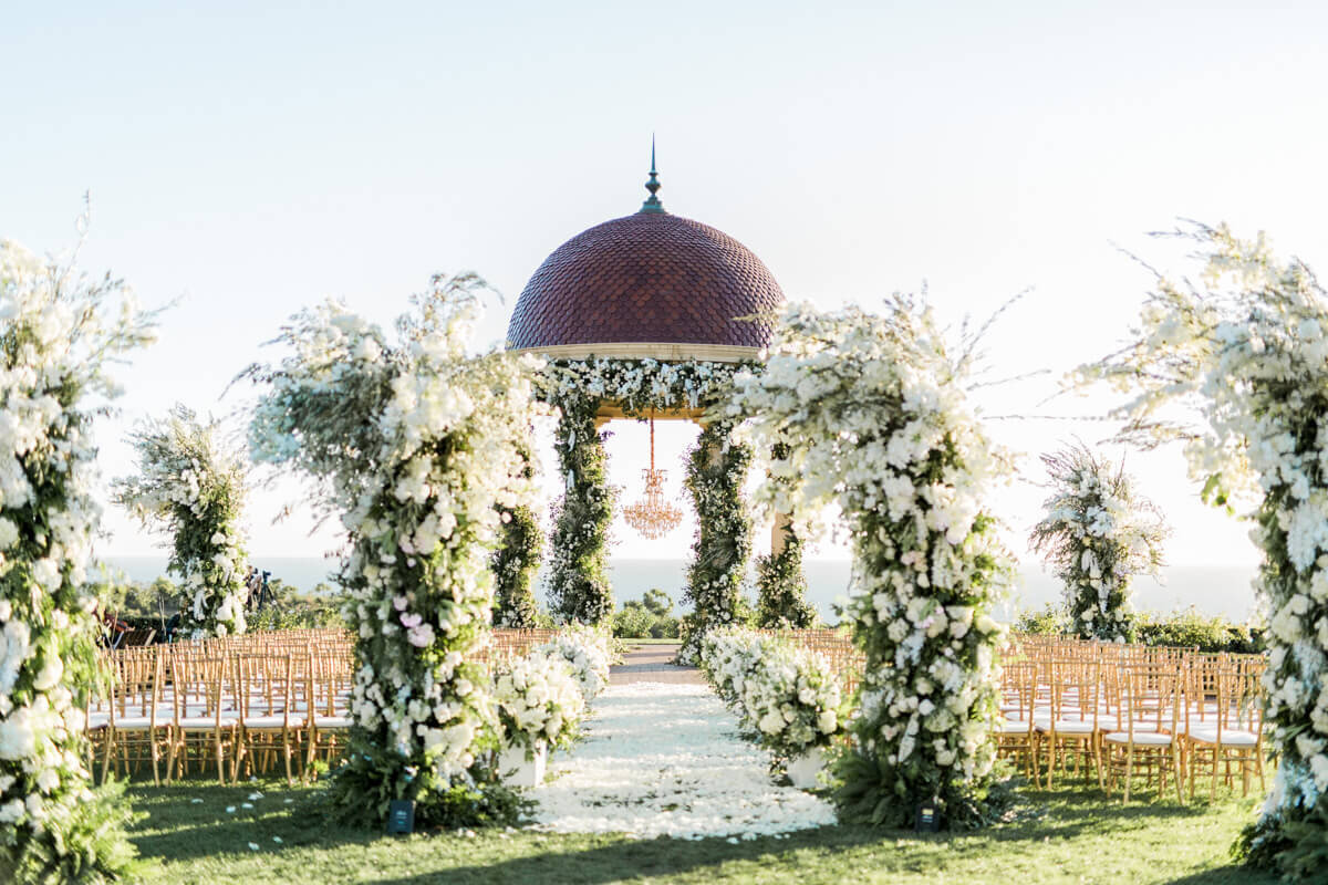 Al fresco wedding reception beneath hanging greenery and citrus