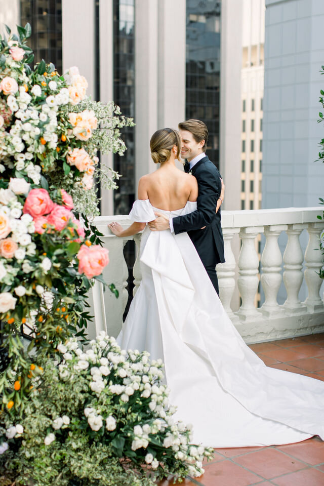 First kiss beneath a floral ceremony arch